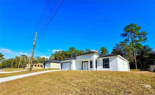 view of front of property featuring a garage and a front lawn