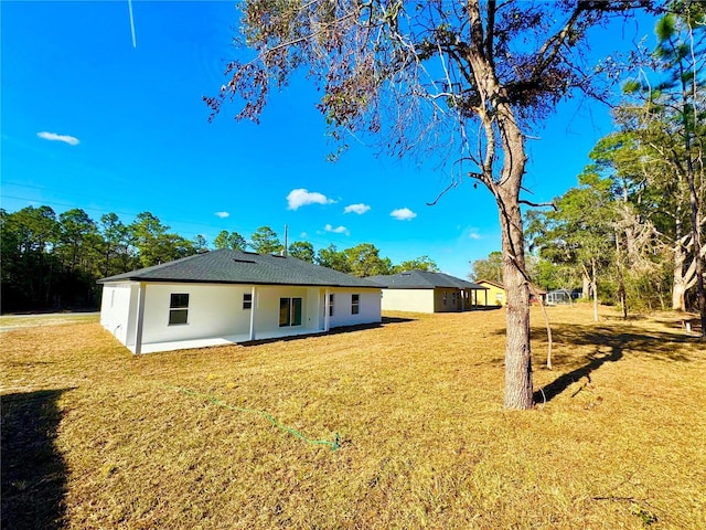 rear view of house with a lawn and a patio