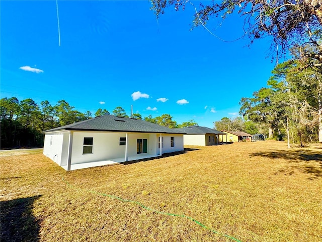 back of house featuring a patio and a yard