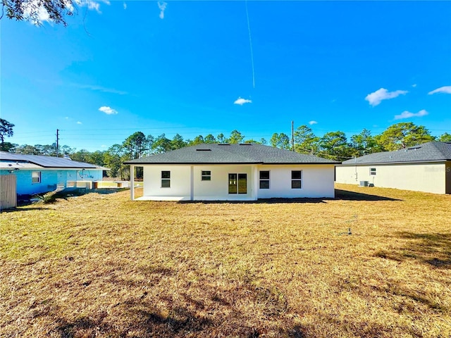 back of property with a yard and a patio area