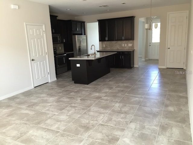 kitchen featuring sink, range with electric cooktop, tasteful backsplash, a center island with sink, and stainless steel fridge with ice dispenser