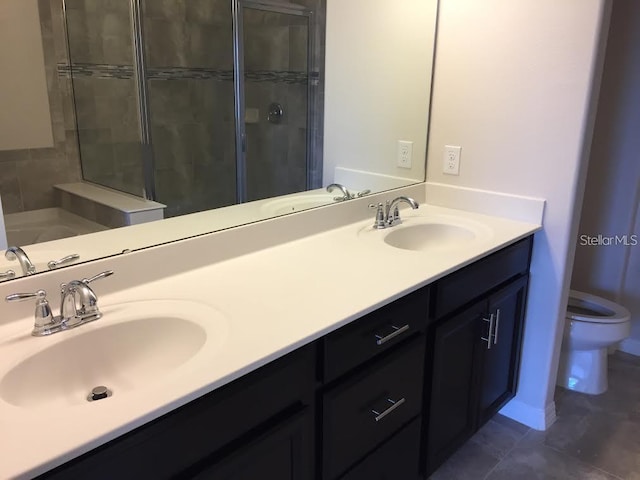 bathroom featuring vanity, toilet, a shower with shower door, and tile patterned flooring