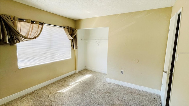 unfurnished bedroom with light colored carpet, a closet, and a textured ceiling