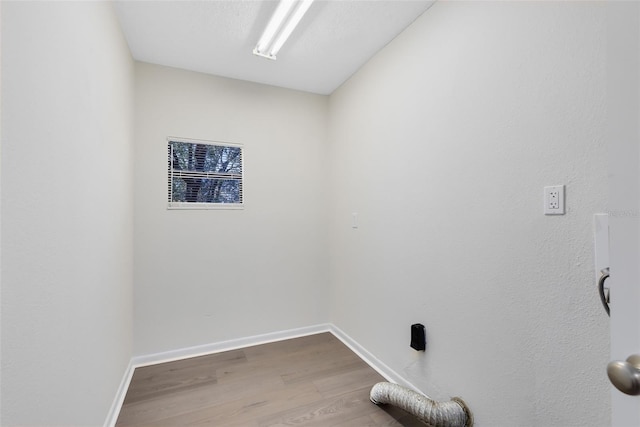 clothes washing area featuring hardwood / wood-style floors and a textured ceiling