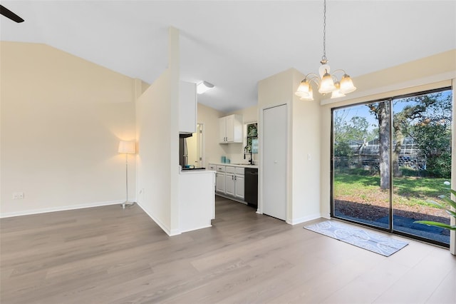 kitchen featuring lofted ceiling, sink, dishwasher, white cabinetry, and decorative light fixtures