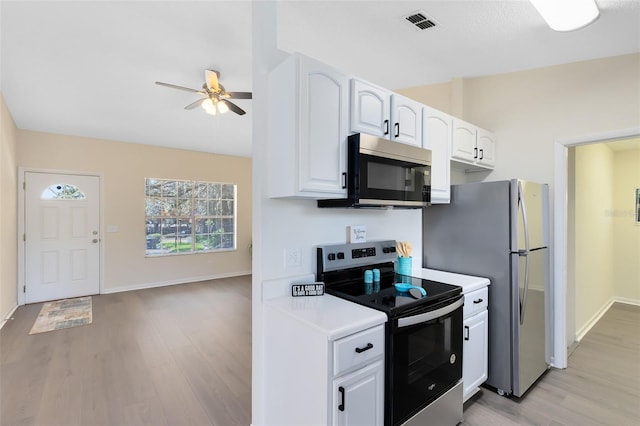 kitchen featuring ceiling fan, appliances with stainless steel finishes, light hardwood / wood-style floors, and white cabinets