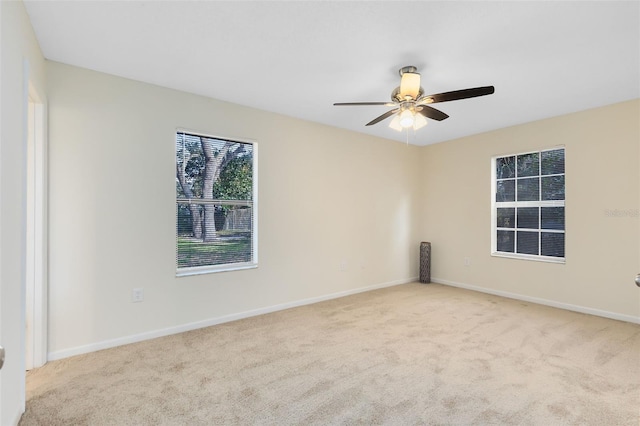 carpeted spare room with ceiling fan