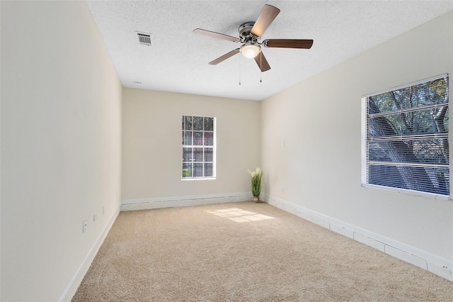 carpeted empty room featuring ceiling fan and a textured ceiling