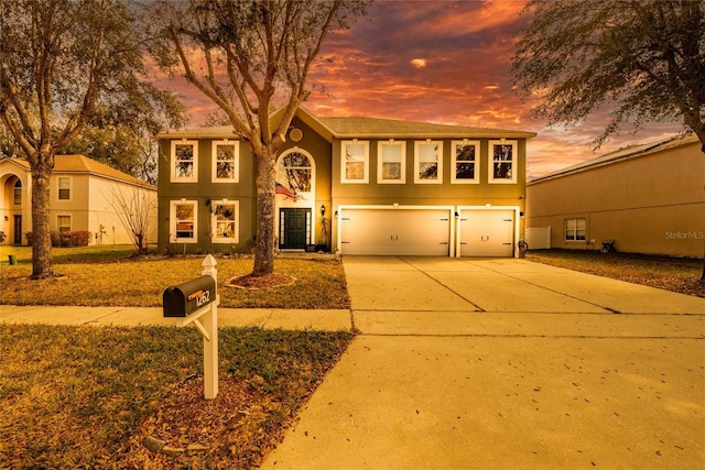 view of front of house with driveway, an attached garage, and stucco siding