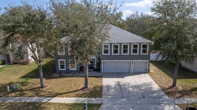 view of front of home with driveway, a shingled roof, an attached garage, a front lawn, and stucco siding