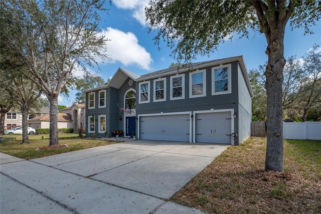 view of front of property with a garage, concrete driveway, stucco siding, fence, and a front yard