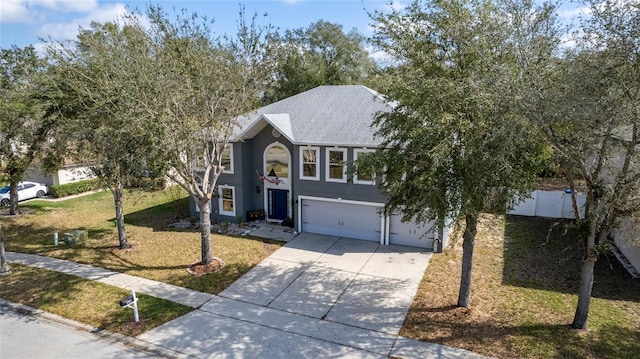 view of front of house with roof with shingles, an attached garage, fence, driveway, and a front lawn