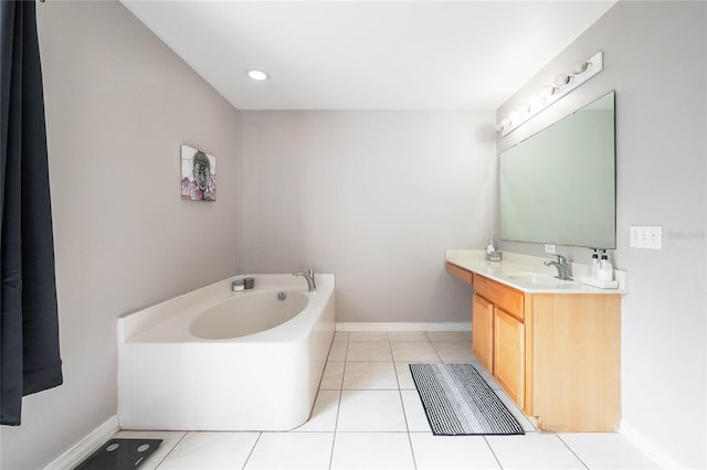 full bath with a garden tub, vanity, baseboards, and tile patterned floors