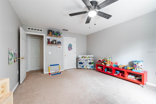 rec room with carpet floors, baseboards, visible vents, and a textured ceiling