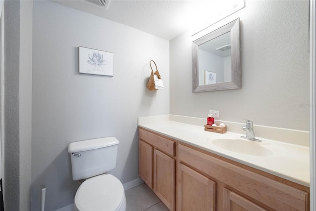 bathroom with toilet, vanity, and tile patterned floors