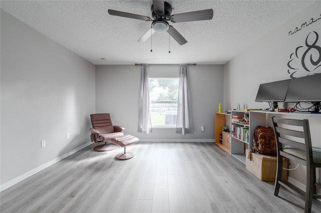 unfurnished room with a textured ceiling, wood finished floors, a ceiling fan, and baseboards