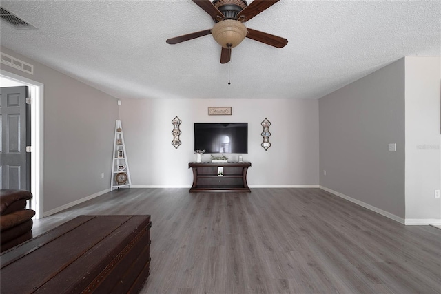 unfurnished living room with visible vents, a textured ceiling, and wood finished floors