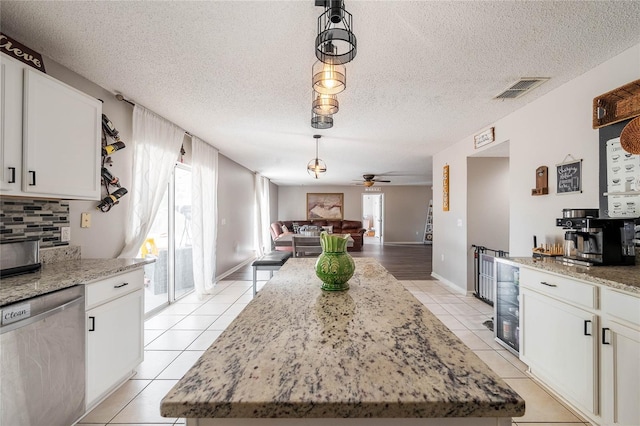 kitchen with light tile patterned floors, visible vents, wine cooler, open floor plan, and stainless steel dishwasher