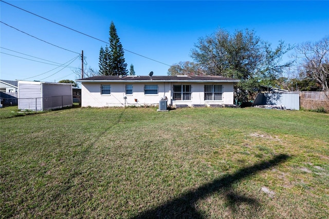 back of house featuring central AC and a lawn