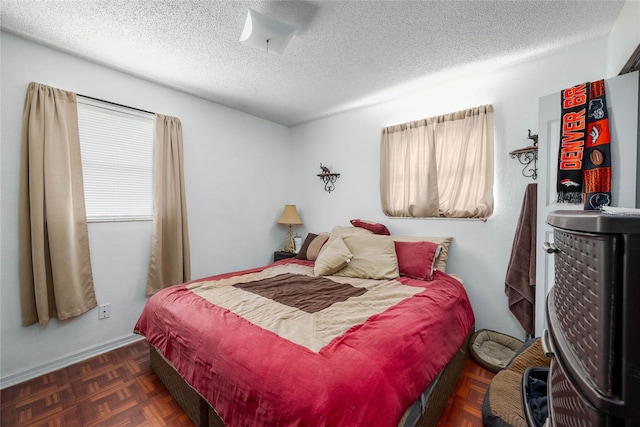 bedroom with dark parquet flooring and a textured ceiling