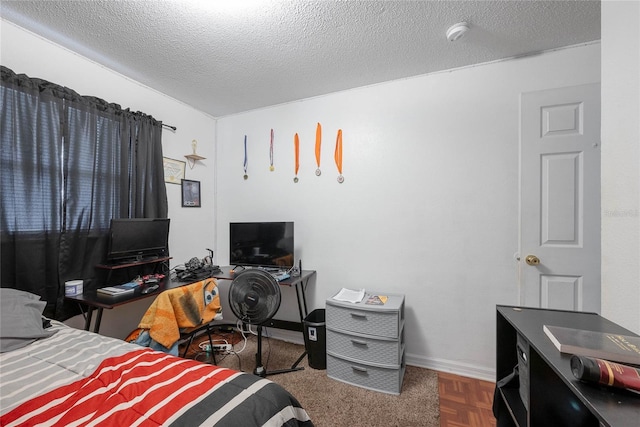 bedroom with parquet floors and a textured ceiling