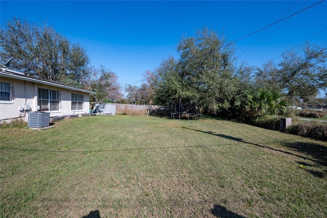 view of yard featuring cooling unit and a trampoline