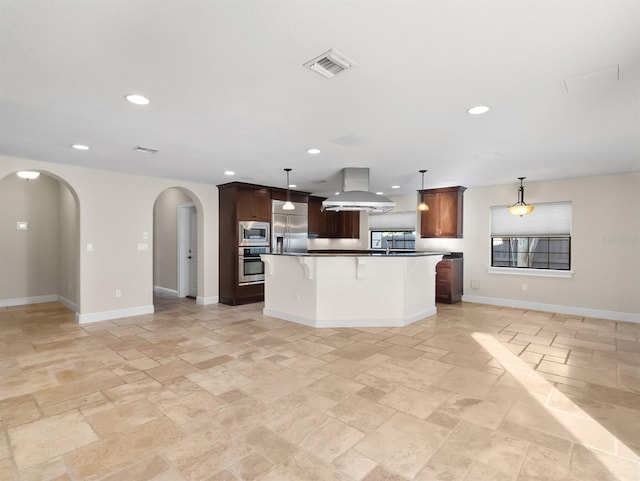 kitchen with island exhaust hood, a kitchen island, built in appliances, and decorative light fixtures