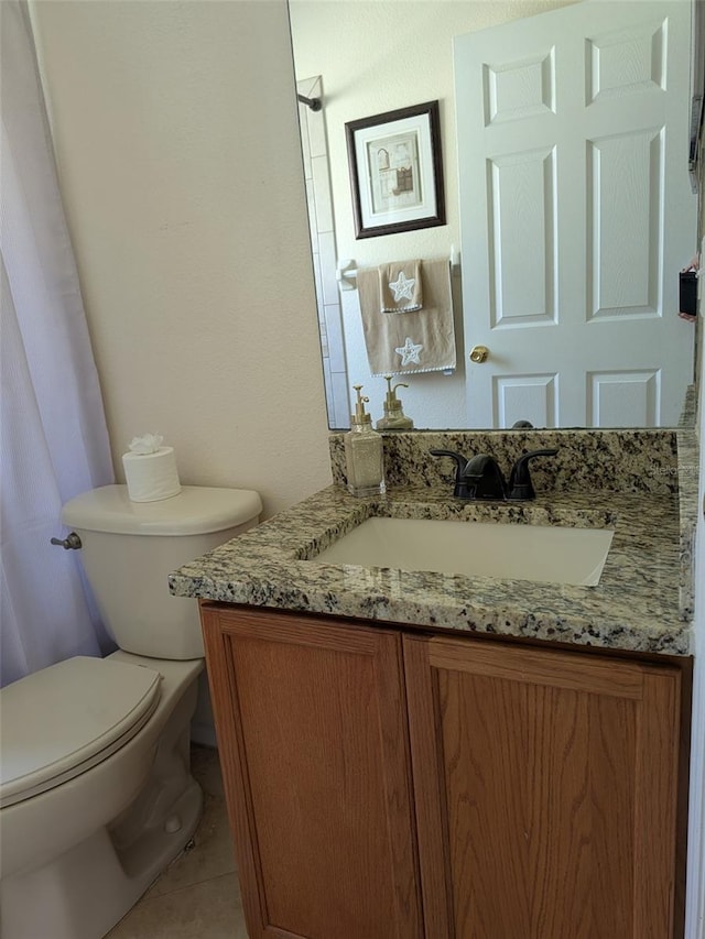 bathroom featuring vanity, tile patterned floors, and toilet