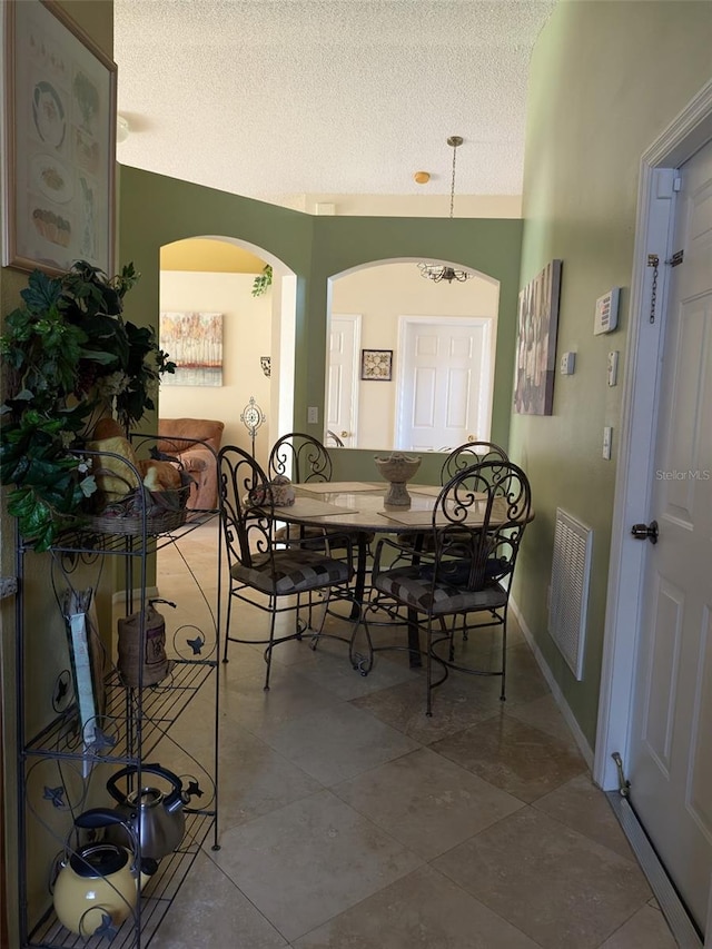 dining area with tile patterned flooring and a textured ceiling