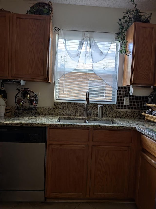 kitchen with stainless steel dishwasher, a healthy amount of sunlight, and sink