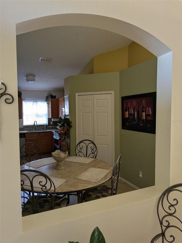 dining space with sink and a textured ceiling