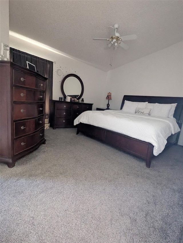 carpeted bedroom with ceiling fan and a textured ceiling