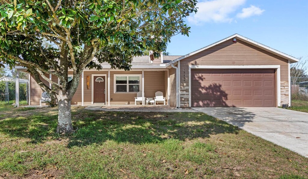 single story home featuring a garage and a front lawn