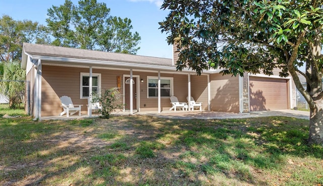 single story home with a porch, a garage, and a front yard