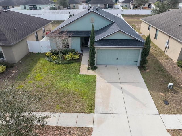 single story home with driveway, a garage, roof with shingles, fence, and a front lawn