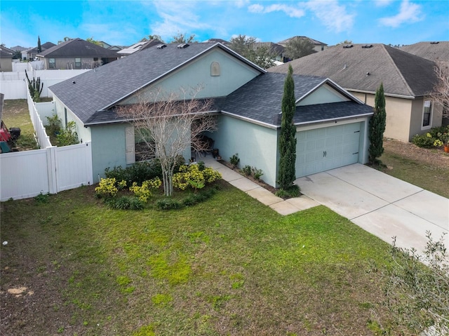 single story home featuring an attached garage, fence private yard, concrete driveway, roof with shingles, and a front yard