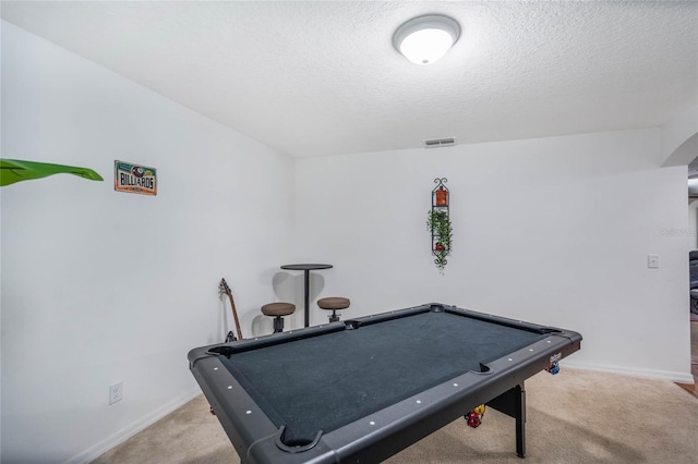 recreation room featuring carpet floors, baseboards, visible vents, and a textured ceiling