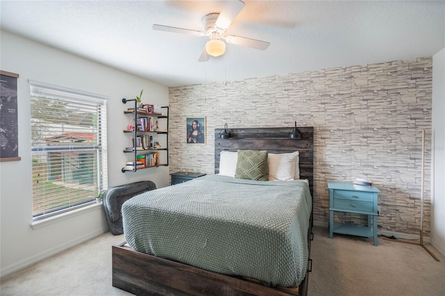 carpeted bedroom with a textured ceiling, ceiling fan, and baseboards