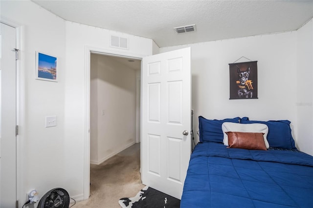 carpeted bedroom featuring visible vents, a textured ceiling, and baseboards