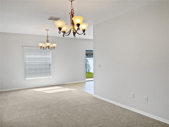 carpeted spare room with an inviting chandelier