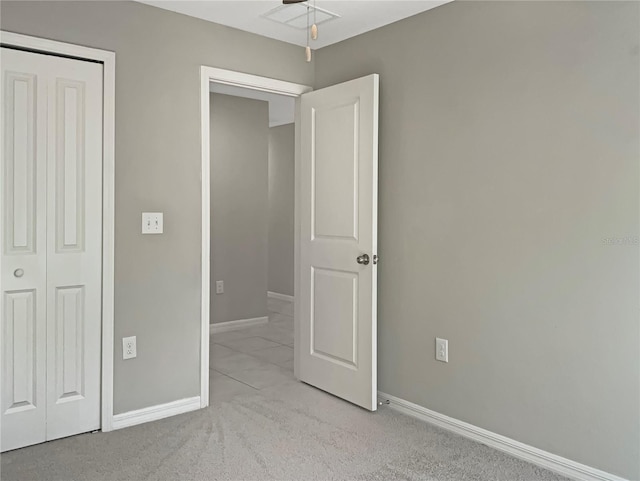 unfurnished bedroom with light carpet and a closet