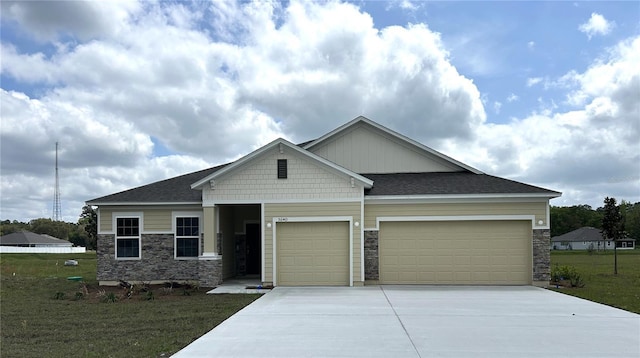 craftsman inspired home with a front yard, stone siding, concrete driveway, and an attached garage