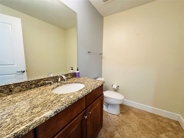 bathroom featuring vanity, tile patterned floors, and toilet