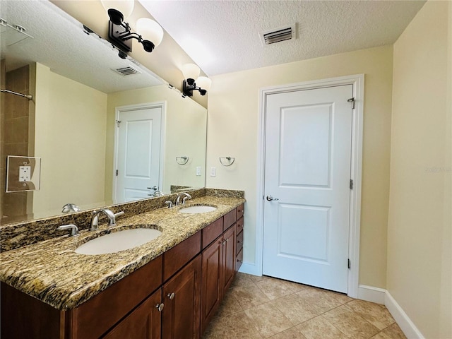 bathroom featuring tile patterned flooring, vanity, and a textured ceiling