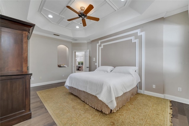 bedroom featuring ceiling fan, ornamental molding, a raised ceiling, and wood-type flooring