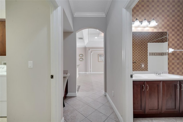 bathroom featuring a shower, washer / dryer, tile patterned flooring, vanity, and crown molding