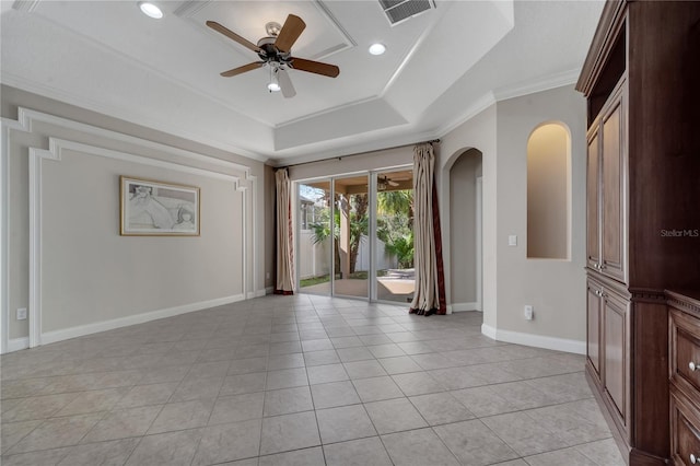 tiled spare room featuring crown molding, ceiling fan, and a tray ceiling