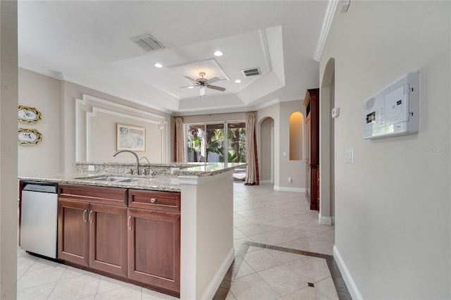 kitchen with sink, ornamental molding, stainless steel dishwasher, light stone counters, and a tray ceiling