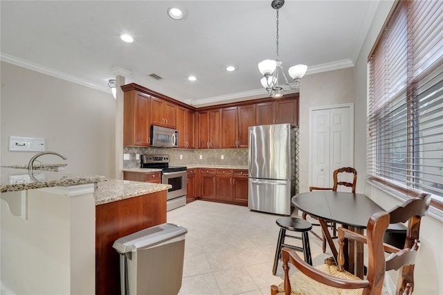 kitchen with crown molding, appliances with stainless steel finishes, light stone countertops, a kitchen bar, and decorative light fixtures