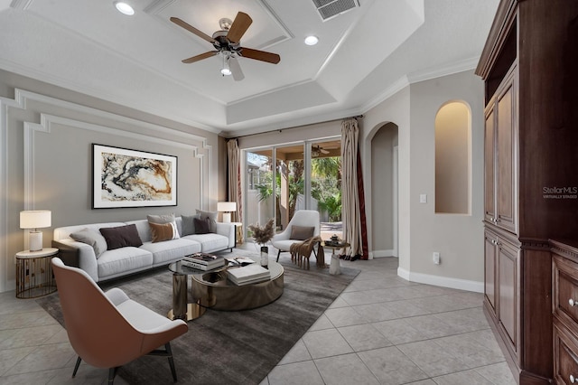 living room featuring ceiling fan, ornamental molding, a raised ceiling, and light tile patterned floors